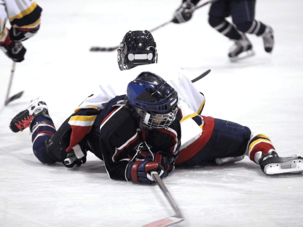 Two Young Ice Hockey Players Fall Over On The Ice During A Practice. Tripping Penalty In Hockey.